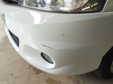 a close up of a white car with a denting on it