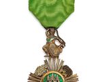 Gros plan sur une médaille ornée d'un ruban vert sur fond blanc
