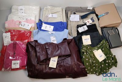 beaucoup de vêtements et un sac à main sur la table