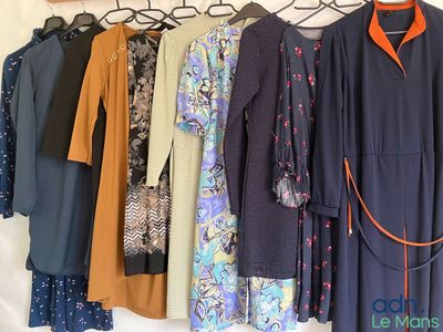 a lot of dresses hanging on a rack in a room
