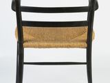 the back of a black chair with a wicker seat