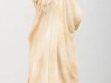 a white statue of a woman standing on a table