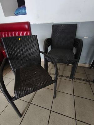 deux chaises noires assises l'une à côté de l'autre sur un sol carrelé