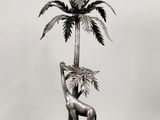 une statue en argent représentant une girafe et un palmier