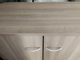 a wooden cabinet with two doors and a drawer underneath it