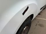 a white truck parked in a parking lot next to a building