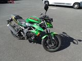 a green motorcycle parked in a parking lot next to a white van