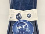 a blue and white plate in a blue box with a label on it