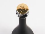 a black bottle with a gold cap on top of it