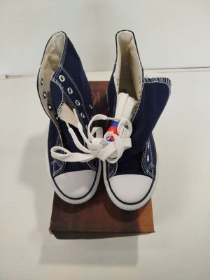 une paire de Converse bleues posées sur un bloc de bois