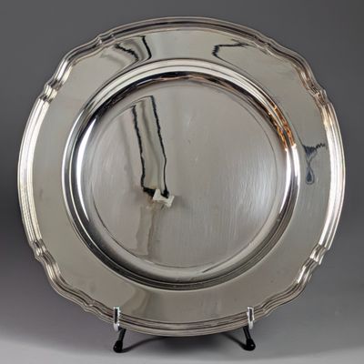 a silver plate with a clock on it on a stand