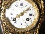 a gold and black clock with roman numerals on it
