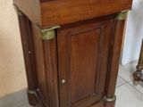 a wooden cabinet with a marble top on a tile floor