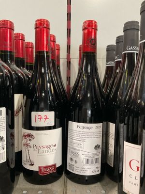 de nombreuses bouteilles de vin sur une étagère dans un magasin
