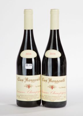 two bottles of red wine sitting next to each other on a white surface