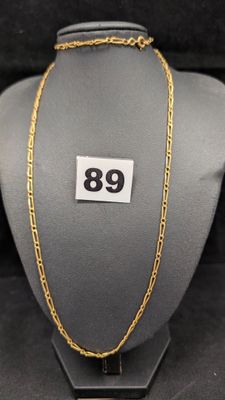 un collier à chaîne en or exposé dans une vitrine