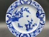 blue and white plate with a bird and flowers design on it