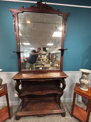 un grand miroir posé sur un pied dans une pièce