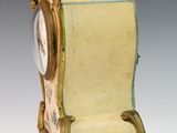 a clock that is sitting on a stand on a table
