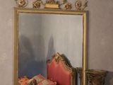 a mirror on the wall above a red chair