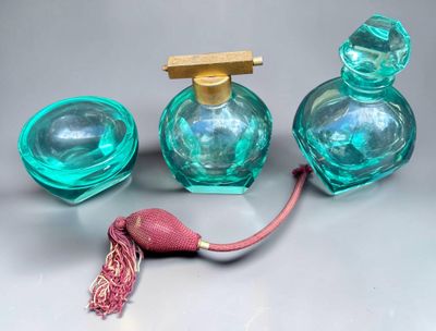 three bottles of perfume on a table with a red cord