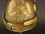 a gold helmet with a red ribbon on top of it