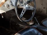 a white car with a black leather seat and steering wheel