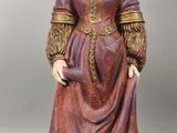 figurine représentant une femme vêtue d'une robe rouge et d'un chapeau marron