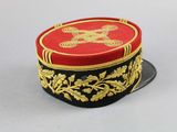 a red and black hat with gold decorations on it