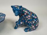 a blue bear figurine sitting next to a blue bowl