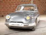 a silver car that is parked in front of a brick wall