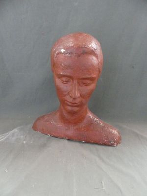 une sculpture en argile représentant la tête d'une femme, posée sur une table