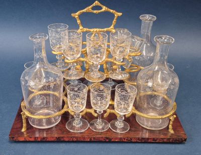 des bouteilles et des verres posés sur un plateau en bois orné d'un cadre doré