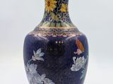 a blue vase with flowers on it sitting on a table