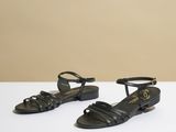 une paire de sandales noires posées sur une surface blanche