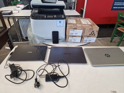 several laptops and a printer are on a table in a room