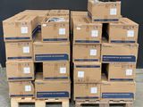 des cartons empilés sur des palettes devant un mur noir