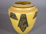 a yellow vase with black and white designs on it