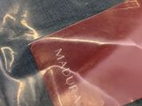 a red packet of makeup sitting on top of a plastic bag