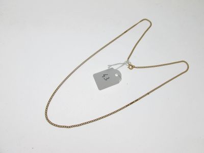 un collier muni d'une étiquette, posé sur une surface blanche
