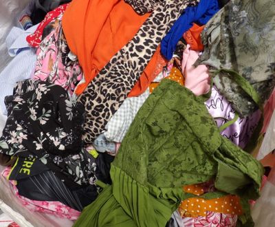 a suitcase full of clothes and clothes sitting on the floor