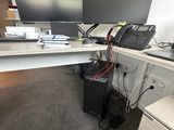 une photo d'un bureau avec deux écrans et un téléphone