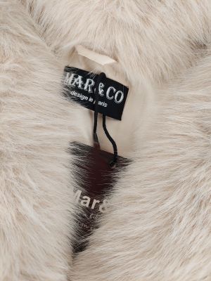 the label on a white fur coat is attached to a black and white tag