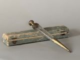 un petit objet métallique surmonté d'une longue lame