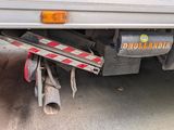 a white truck with a red and white stripe on the back of it