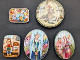 four small tins with pictures of children on them sitting on a table