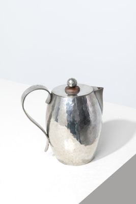 an image of a silver teapot sitting on top of a white table