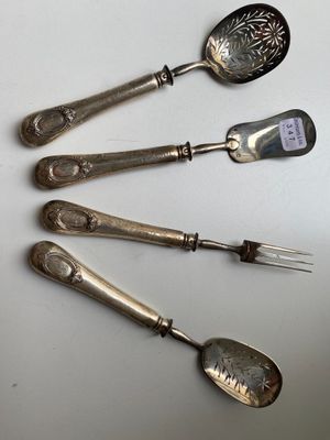 four silver spoons and a fork on a white surface