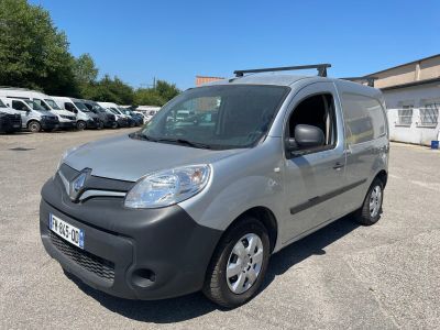 La camionnette grise est garée sur un parking, à côté d'autres voitures.