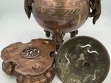 three bronze objects are sitting next to each other on a white surface